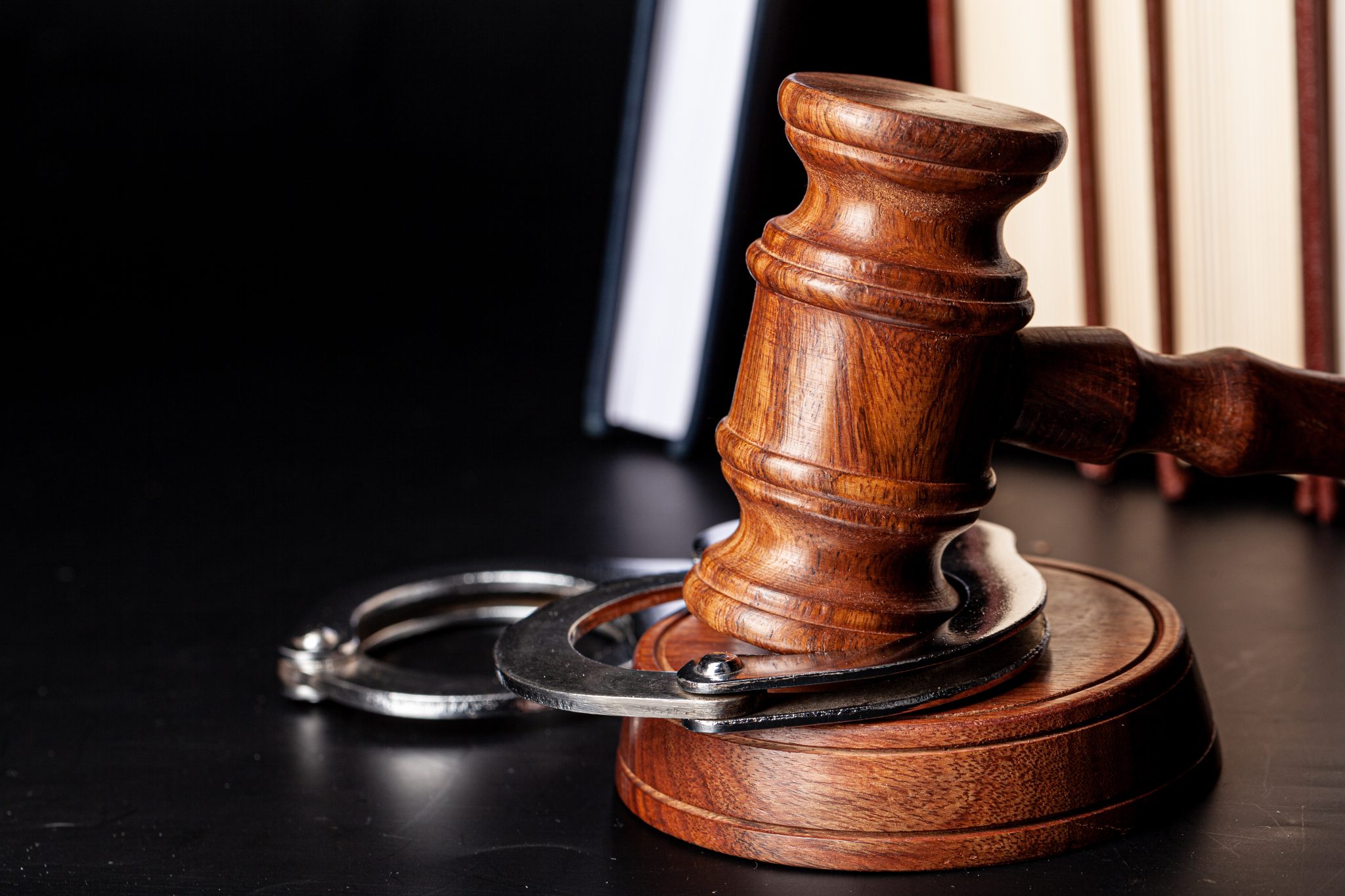Wooden gavel and juridical books close up