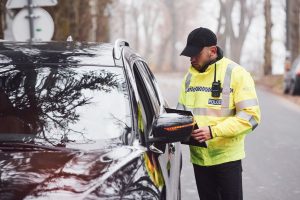male-police-officer-in-green-uniform-checking-vehi-2023-11-27-05-26-22-utc