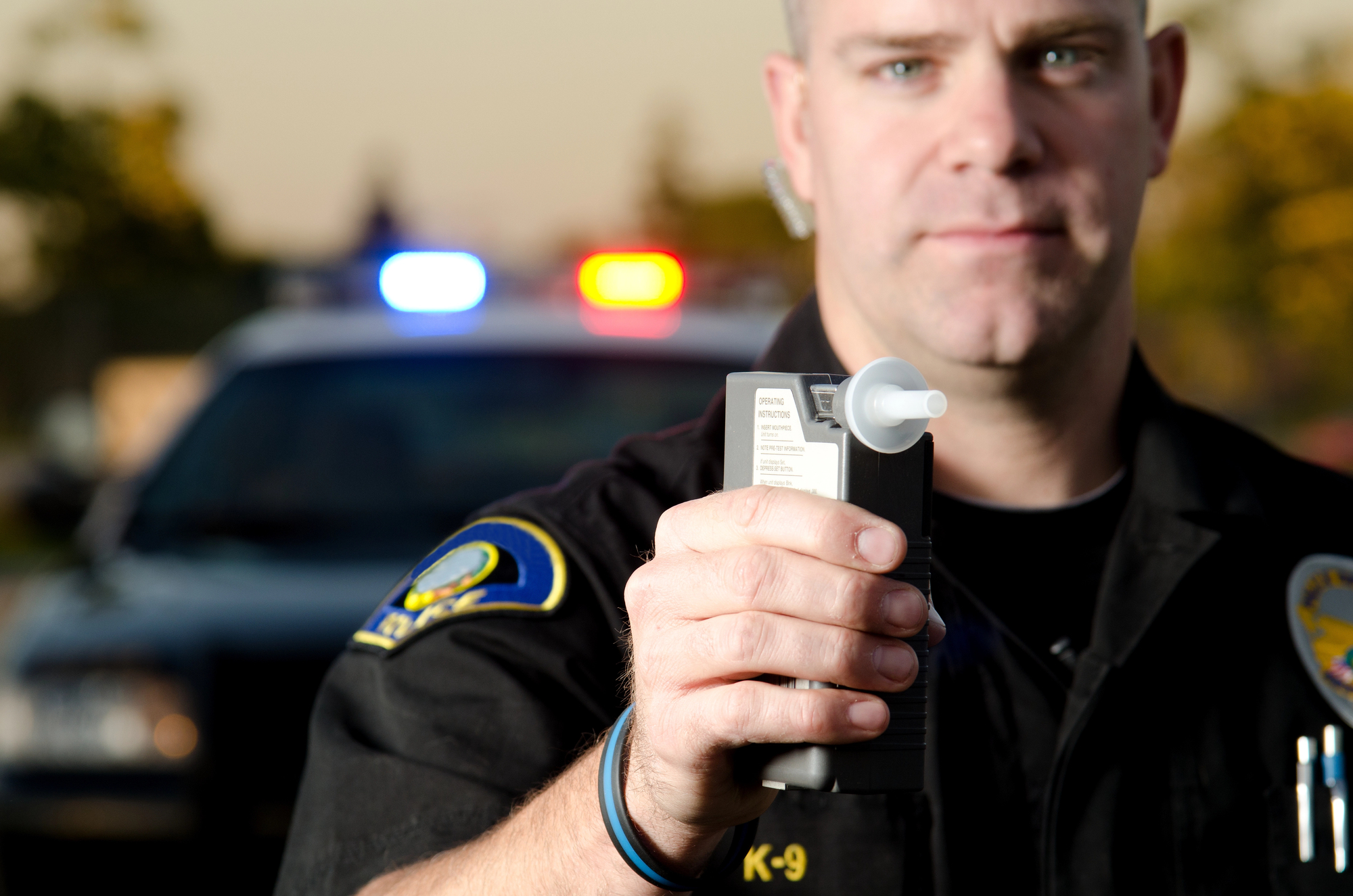 officer holding a breathalyzer