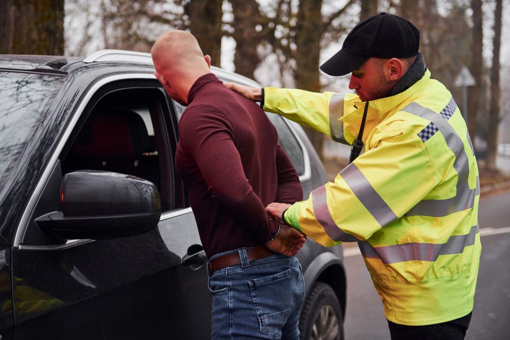 the-police-officer-in-green-uniform-detains-man